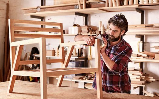 imagen de empresario tallando una silla de madera