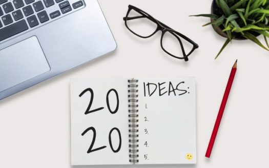 lista de ideas 2020 escrito sobre libreta, laptop, gafas, lápiz, maceta con planta sobre escritorio
